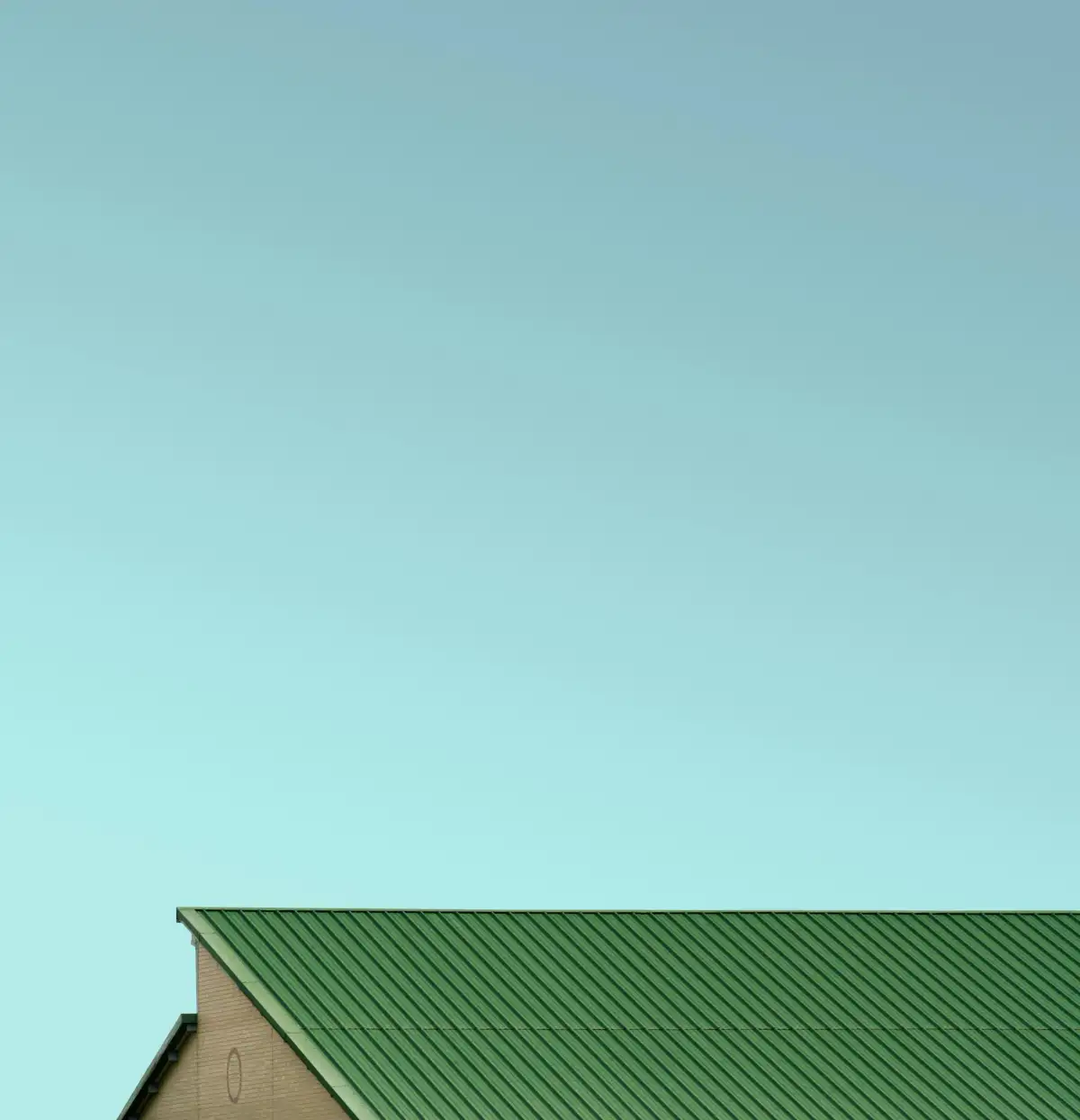Green standing-seam metal roof against a clear sky